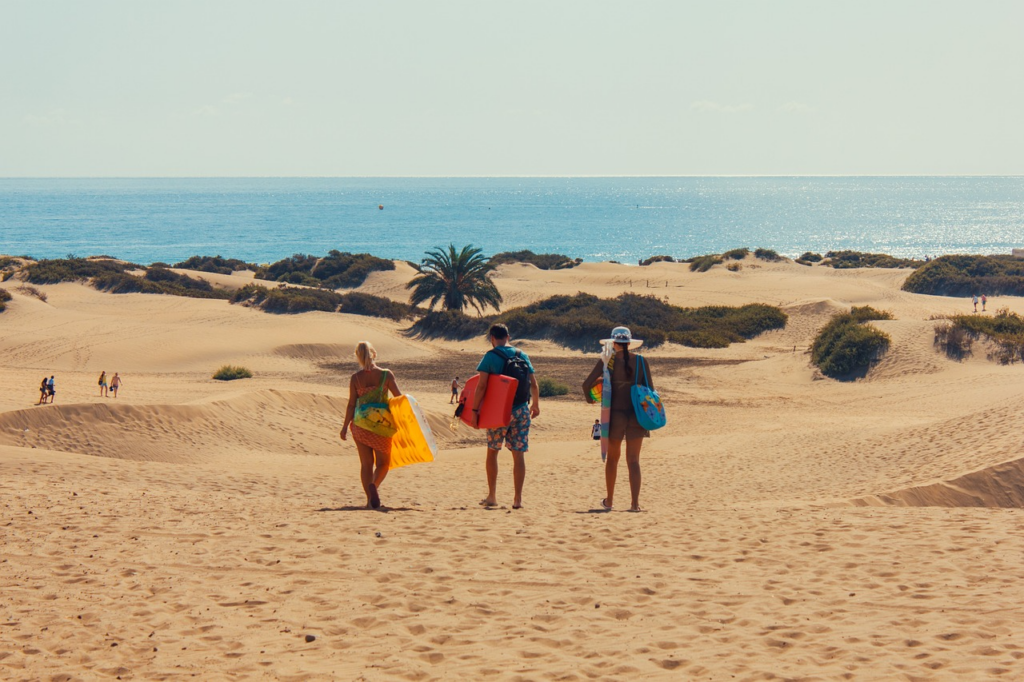 Playa de Maspalomas auf den Kanaren: heller Strand, transparentes Wasser und leichte Brandung.
