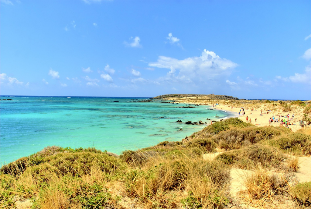 Rosa schimmernder Sandstrand von Elafonisi auf Kreta mit türkisfarbenem Wasser und flacher Lagune.