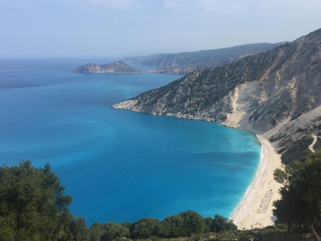 Blick auf die halbmondförmige Bucht von Myrtos Beach auf Kefalonia mit weißem Kiesstrand und türkisblauem Wasser